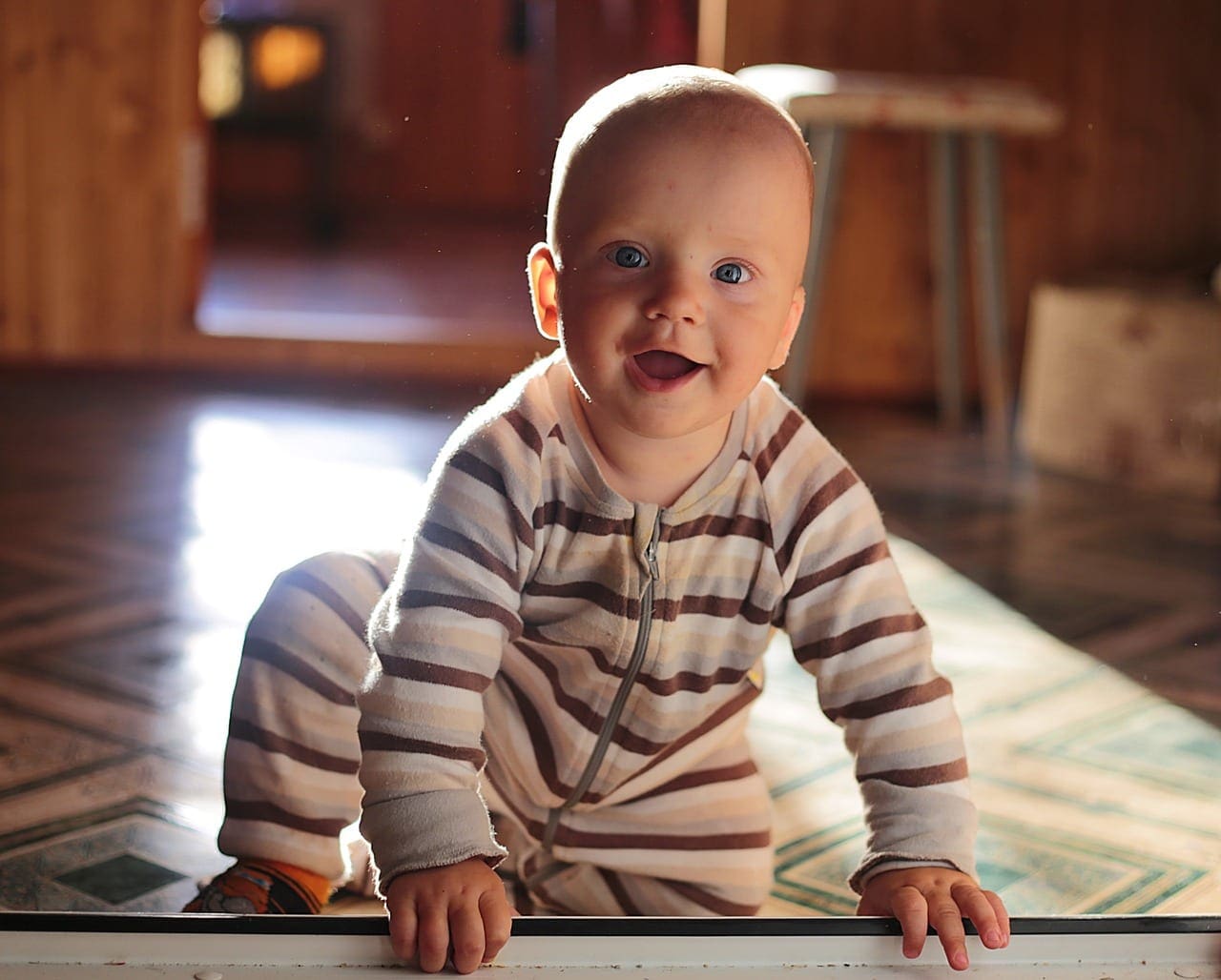 child sitting on floor child crawaling on the floor